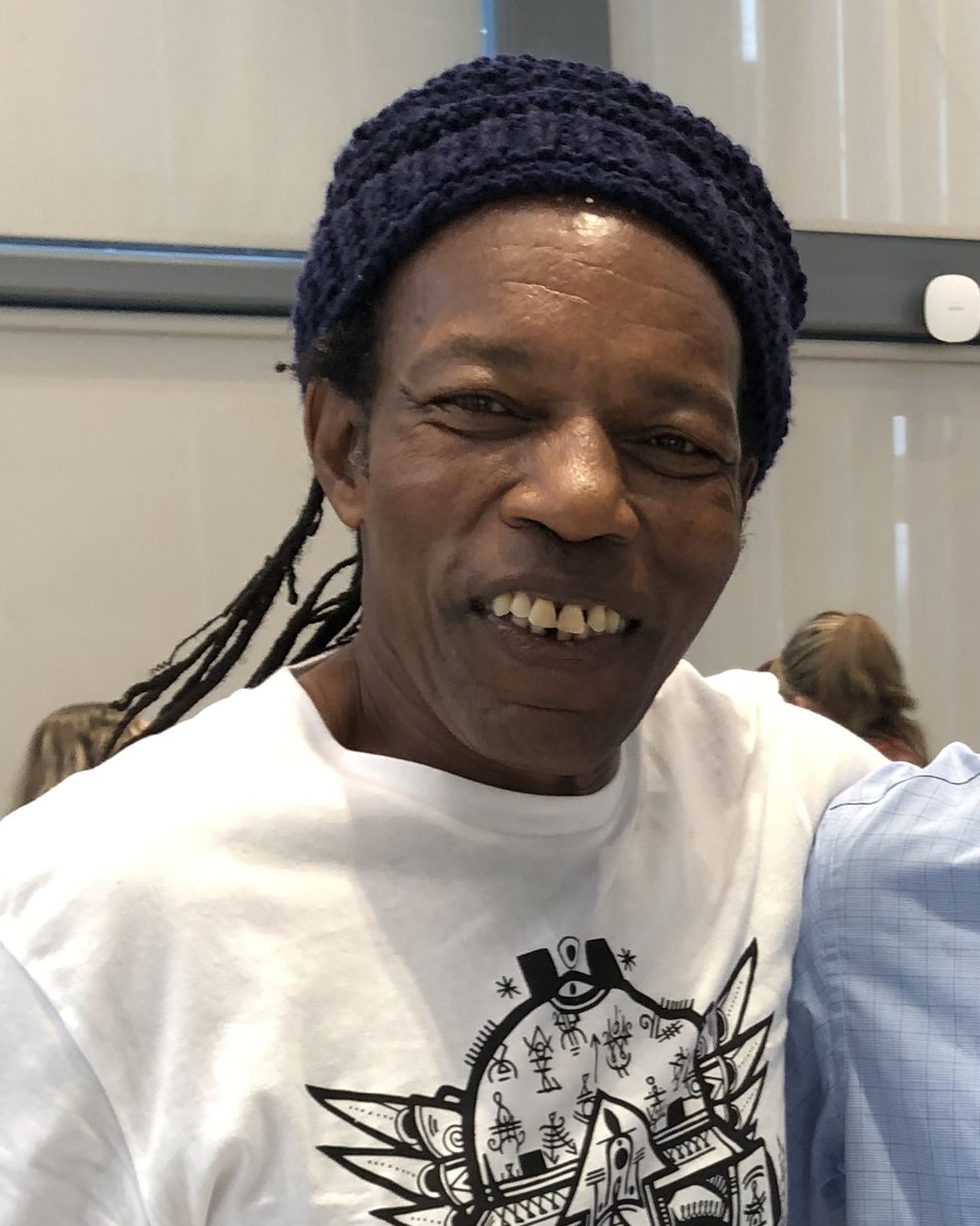 Lou Duncanson of Green Garden Organics smiling, wearing a dark knit cap and a white T-shirt