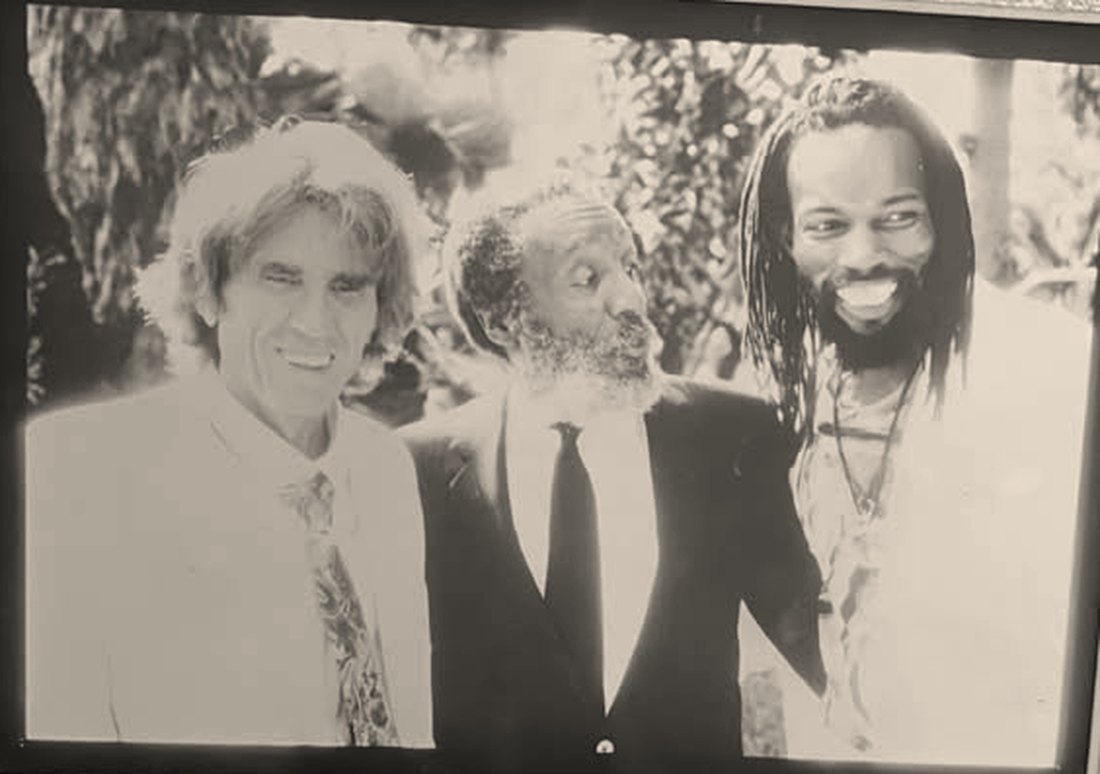 Black and white photograph from 1991 showing Viktoras Kulvinskas, Dick Gregory and Louis Duncanson standing together outdoors
